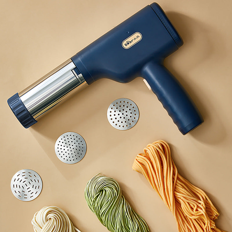 Handheld Electric Noodle Machine with attachments and noodles on a beige background