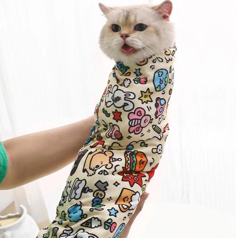 Cat wearing a colorful patterned Magic Pet Wrap with cartoon designs on a white background