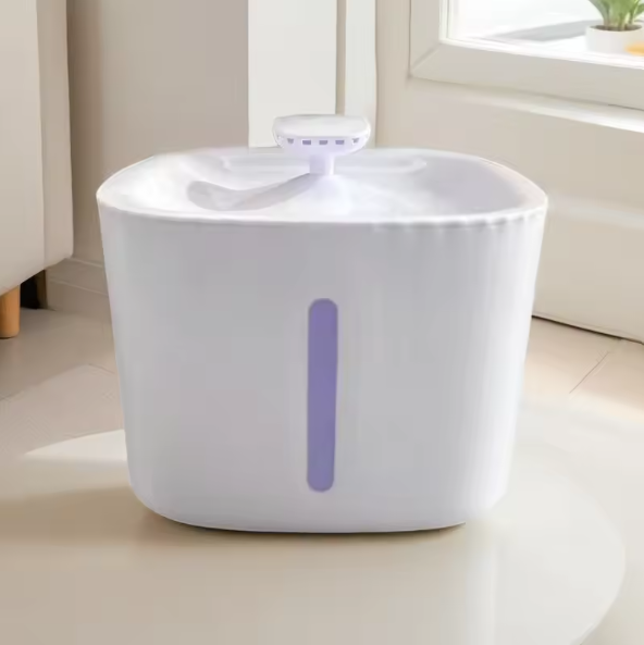 White cat water fountain with a purple light on a light-colored floor.